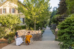 two women sitting on chairs outside