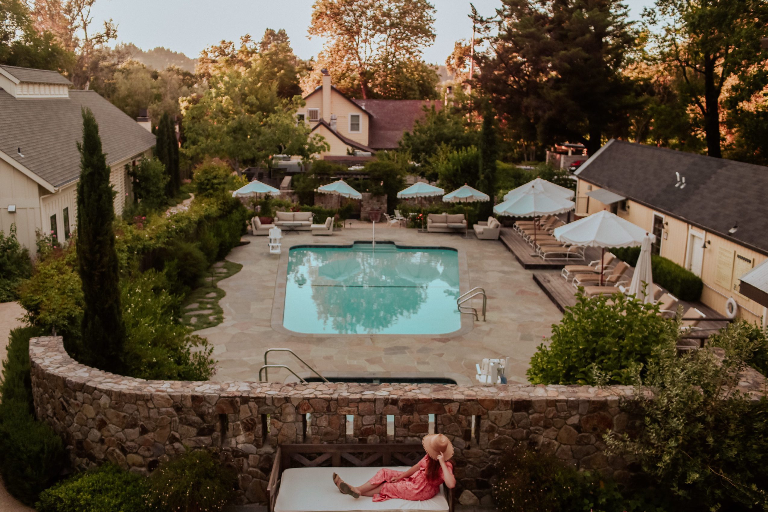 aerial shot of Farmhouse pool with woman sitting on a bench