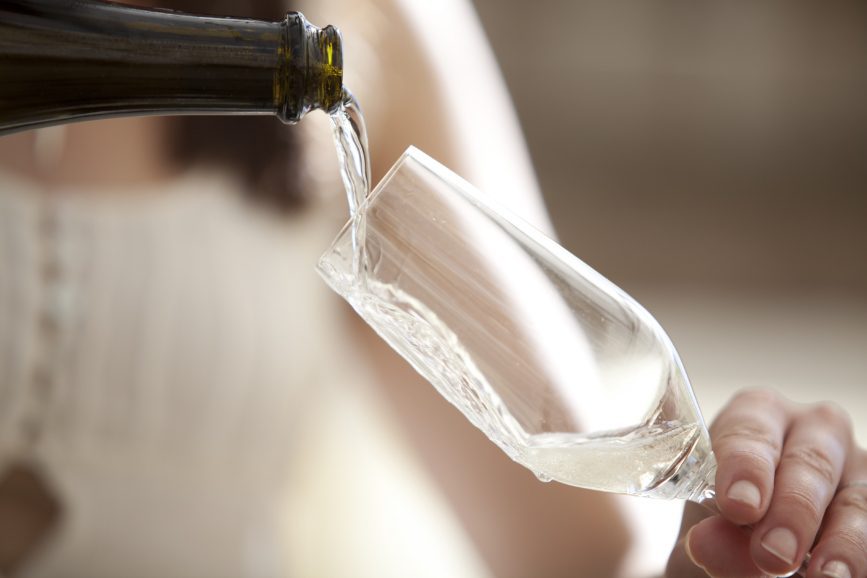 close up shot of a woman pouring a glass of champagne