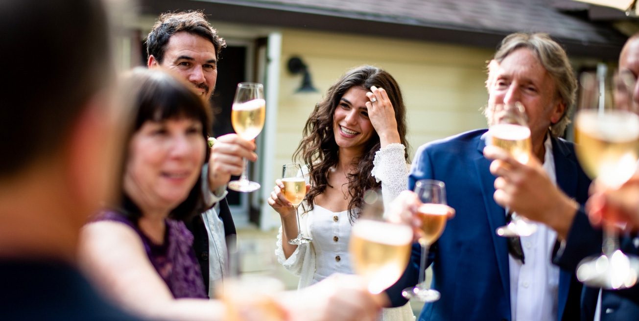 group of people toasting with glasses of white wine