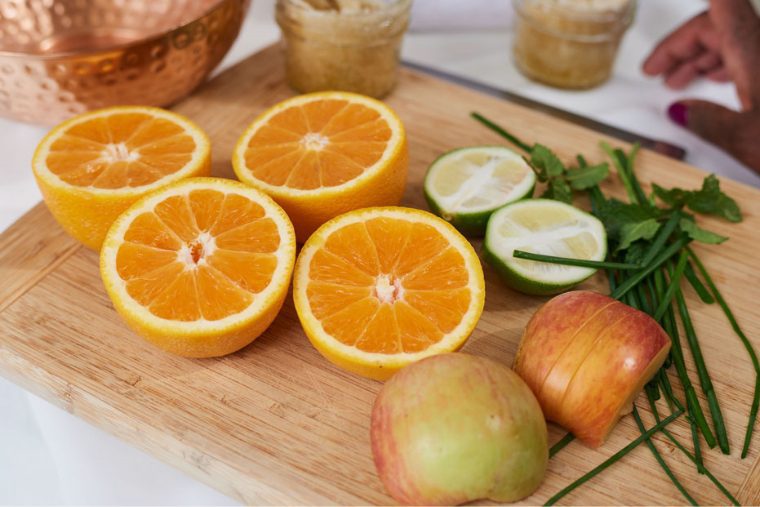 close-up of cutting board with sliced oranges lime and apple