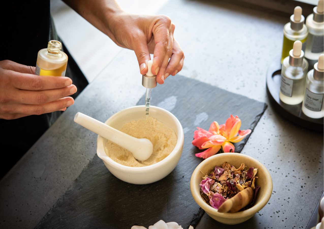 woman making treatment powder in the spa with essential oils.