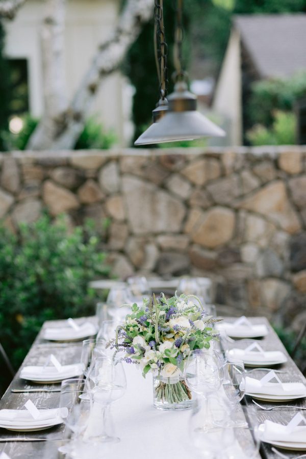 Farmhouse outdoor table set for a wedding event, flower centerpiece and white linen table setting