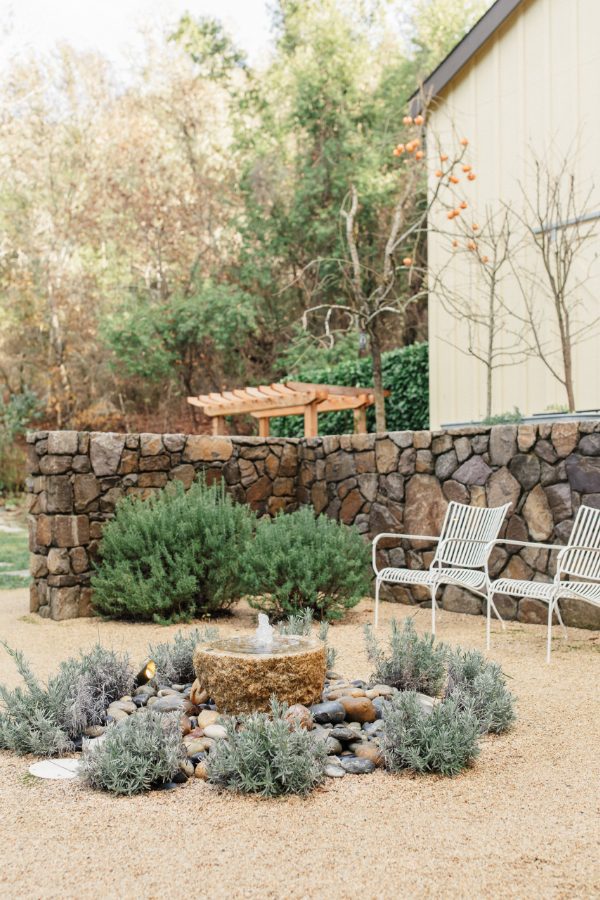 Farmhouse back patio near barn rooms with fountain