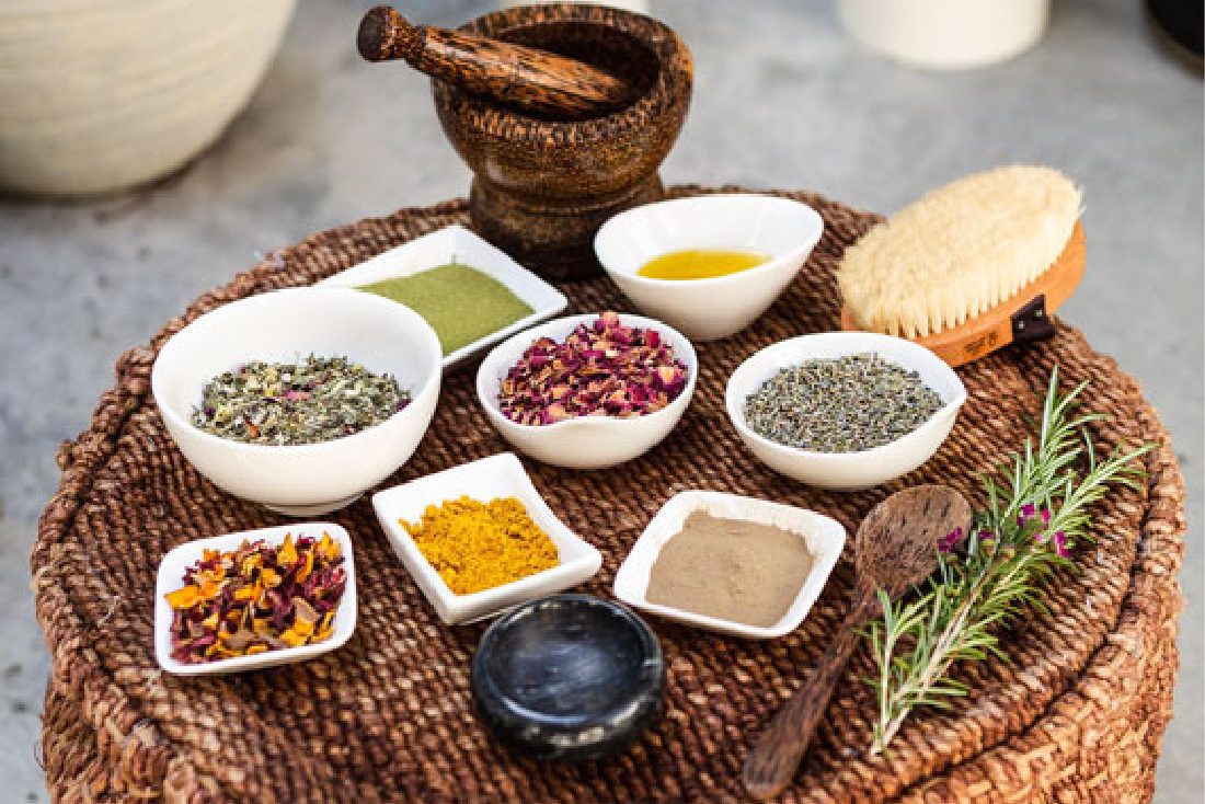 Wicker table with several bowls of natural restoring products used in the Wellness Barn