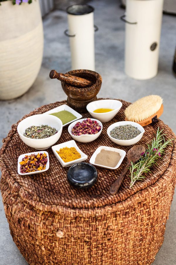 Wicker table with several bowls of natural restoring products used in the Wellness Barn