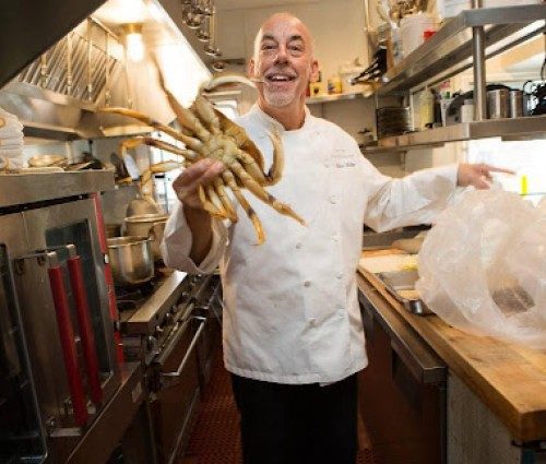 Chef Steve Itkie holding crab in the kitchen