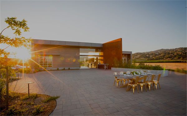 Zialena winery- outside dining table next to a building with sunset and hills in the background
