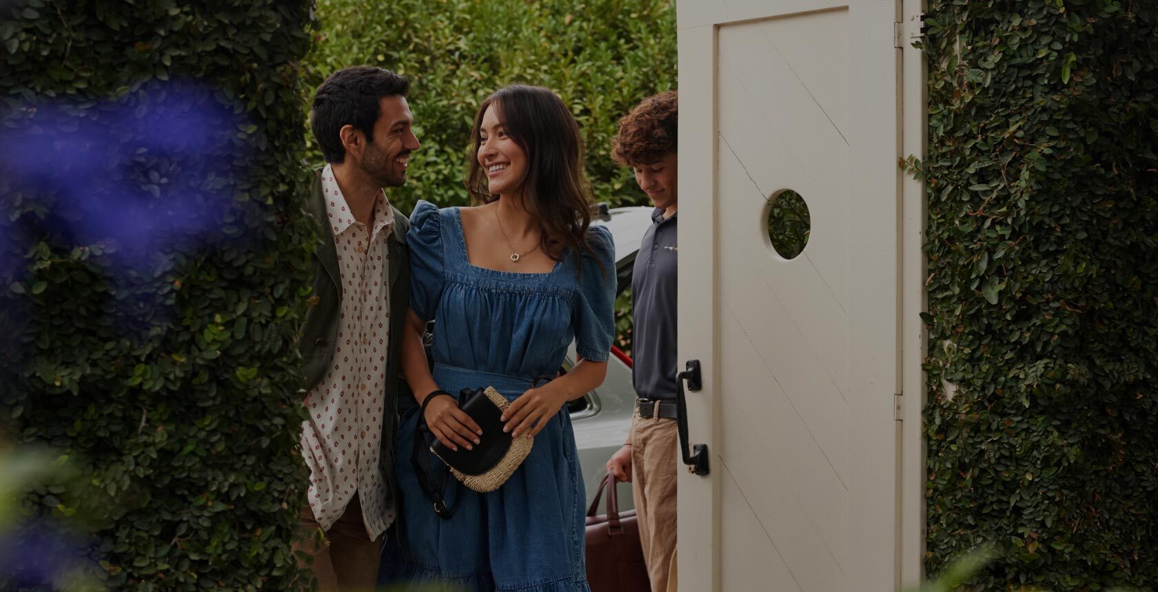 Man and woman couple in evening attire walking into the Farmhouse Inn from outside.