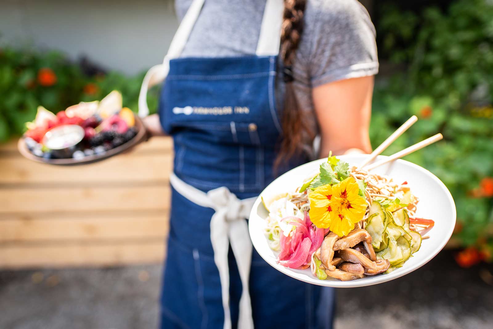 women holding plate of food at farmstand