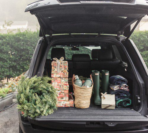 Christmas presents, a wreath, and other goods in the back of a car's trunk