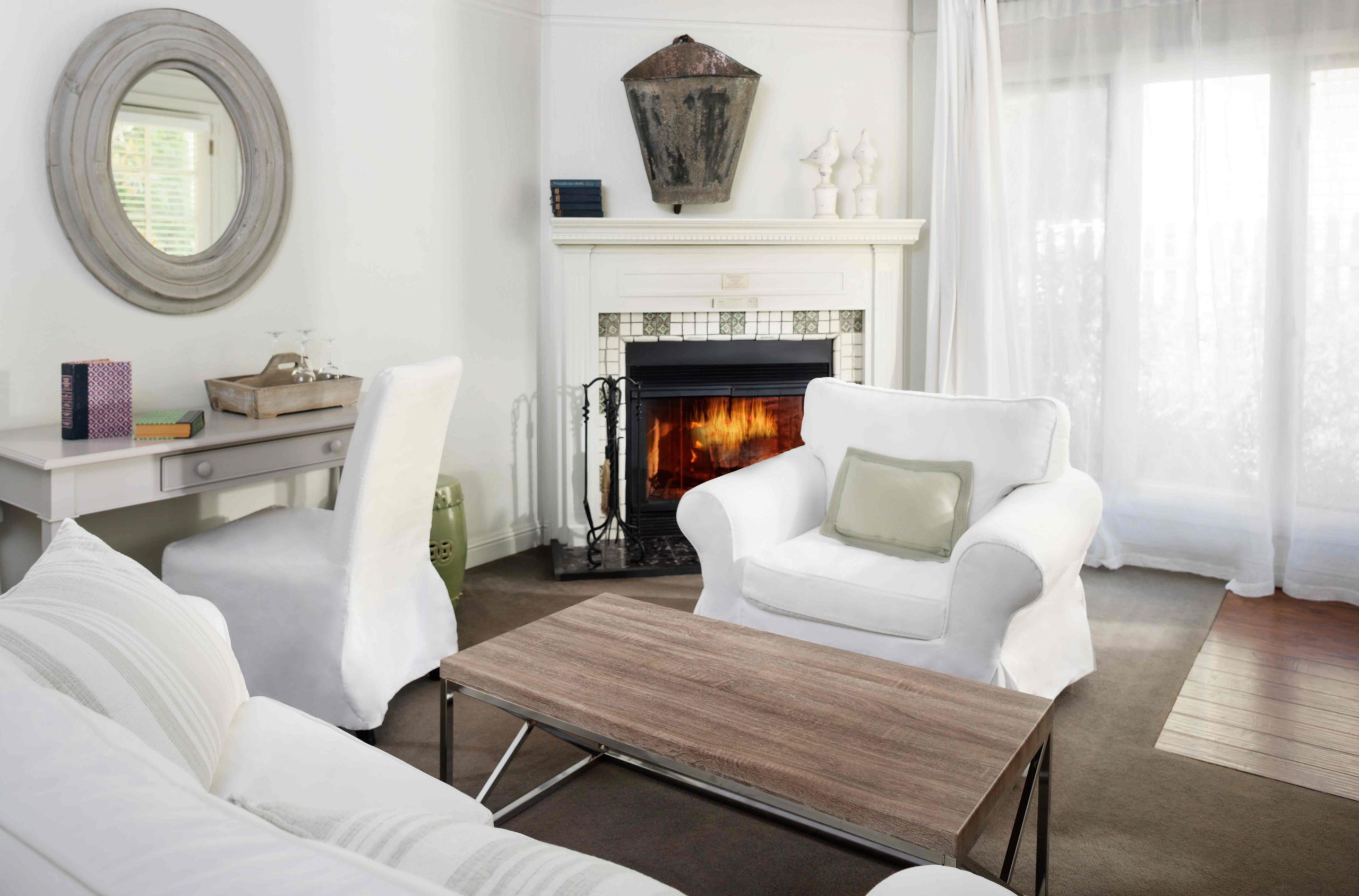 Old photo in Cottage Suite sitting area with couch, table, chair, desk space, and fireplace