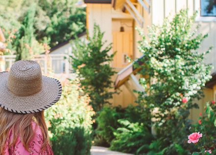 Behind view of a blonde-haired woman walking down a path at the Farmhouse Inn