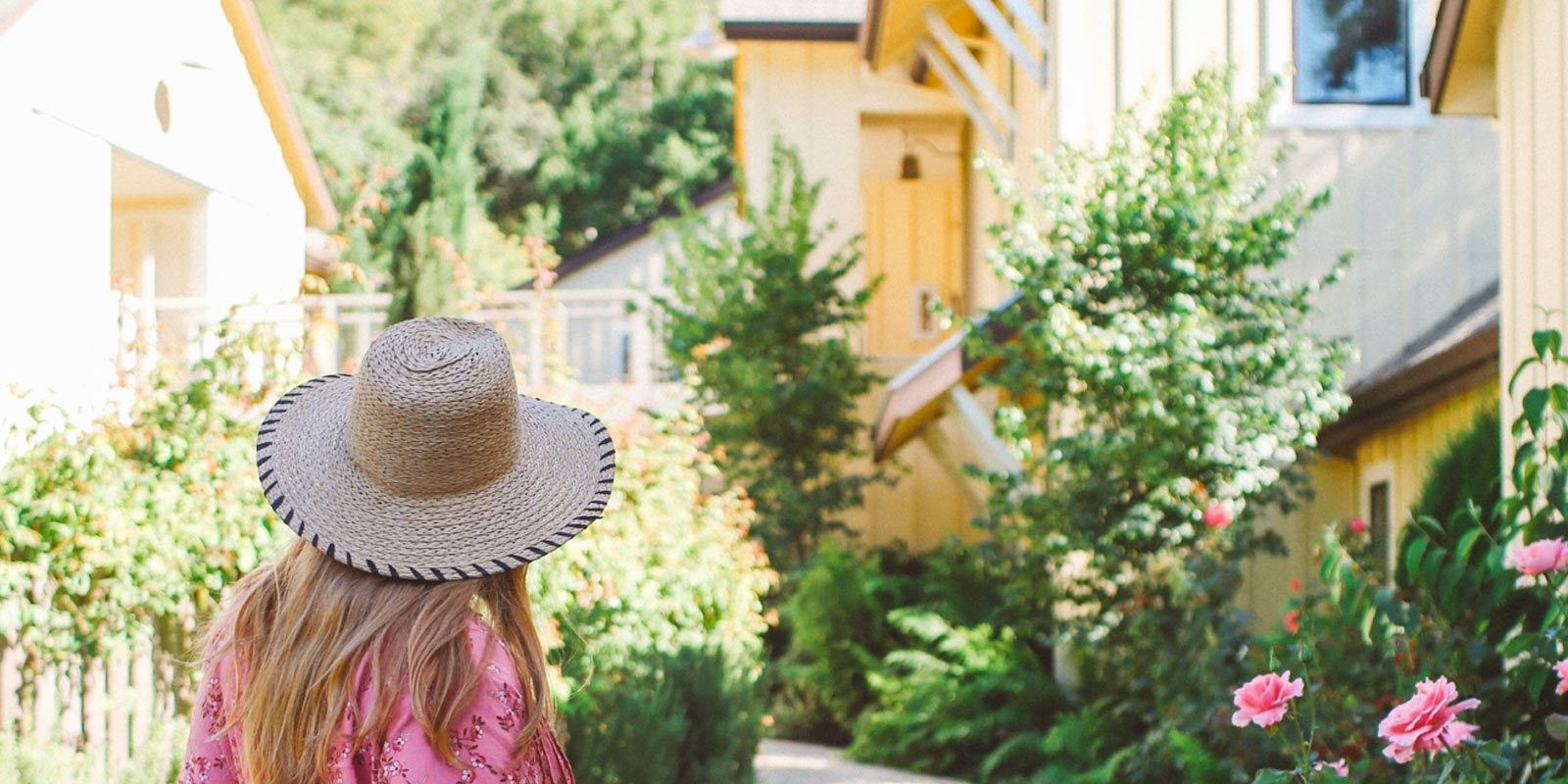 Behind view of a blonde-haired woman walking down a path at the Farmhouse Inn